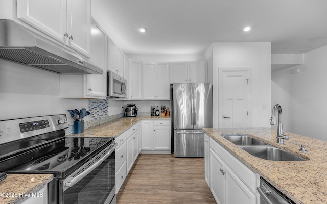 kitchen with appliances with stainless steel finishes, sink, light stone countertops, and white cabinets