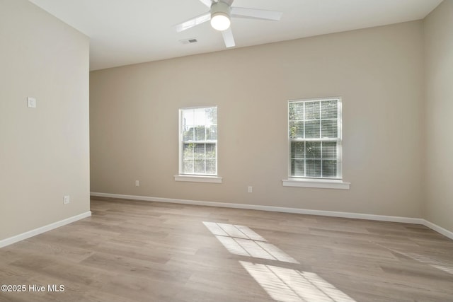 unfurnished room with ceiling fan, light wood-type flooring, visible vents, and baseboards