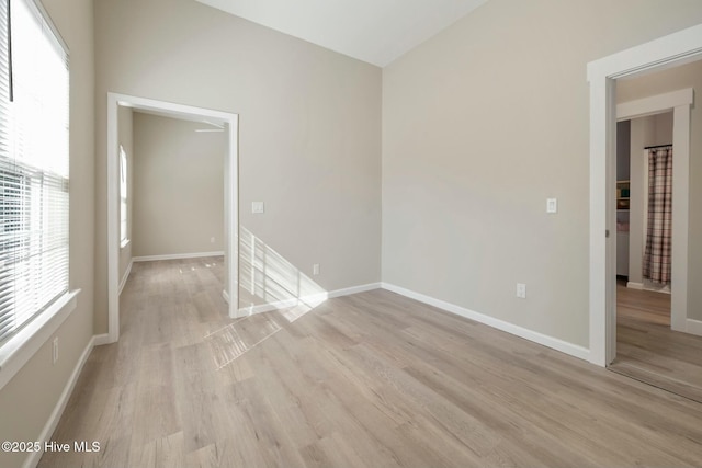 unfurnished room with light wood finished floors and baseboards