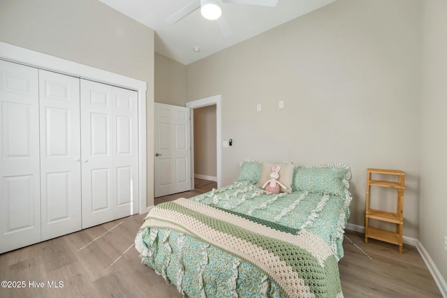 bedroom featuring a closet, wood finished floors, a ceiling fan, and baseboards