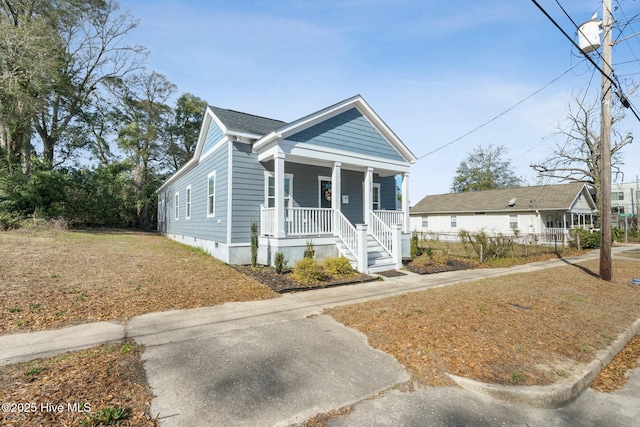 view of front of house featuring roof with shingles, a porch, and crawl space