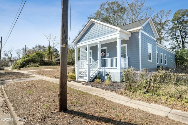 view of front of house featuring covered porch and a shingled roof