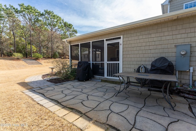 view of patio / terrace with a sunroom and a grill