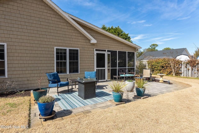 view of patio featuring a sunroom and a fire pit