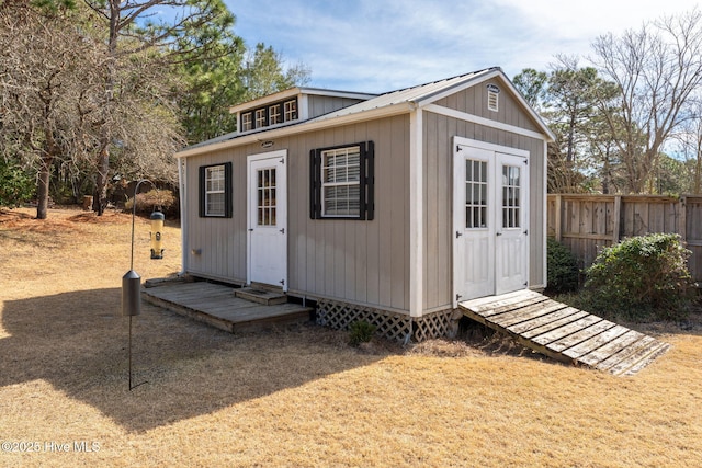 view of outdoor structure with an outbuilding and fence