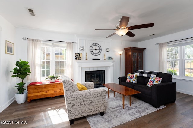 living room with dark hardwood / wood-style flooring, ceiling fan, and a fireplace