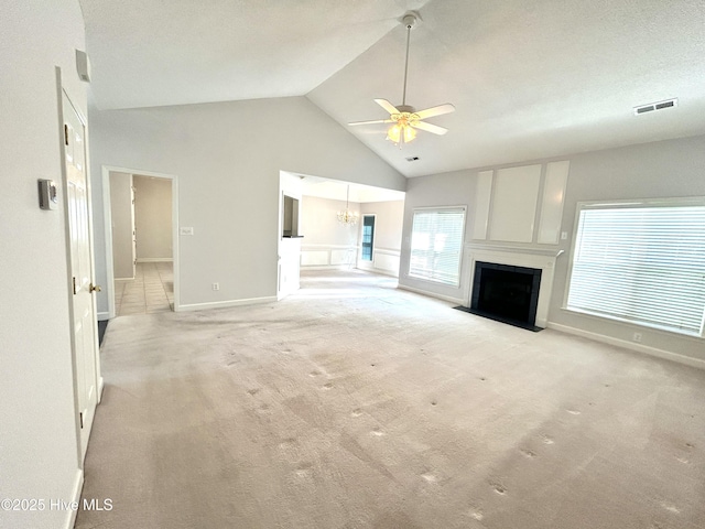 6237 Sentry Oaks Dr, Wilmington, NC 28409 - unfurnished living room with a ceiling fan, high vaulted ceiling, a large fireplace, light colored carpet, and a chandelier
