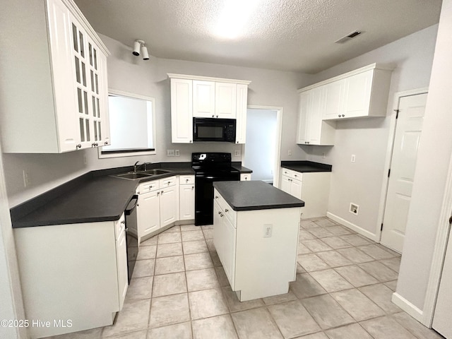 6237 Sentry Oaks Dr, Wilmington, NC 28409 - kitchen with black appliances, dark countertops, a textured ceiling, white cabinets, and a center island
