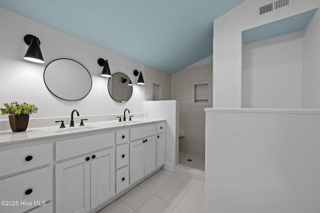 full bathroom with double vanity, tile patterned flooring, visible vents, and a sink