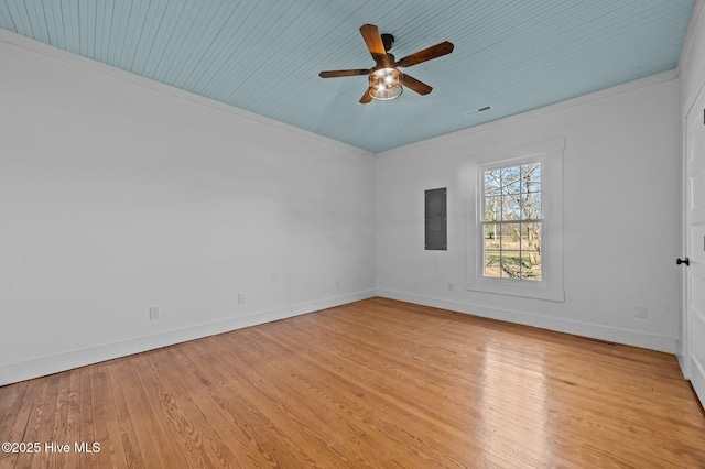 empty room featuring light wood-style flooring, a ceiling fan, baseboards, ornamental molding, and electric panel