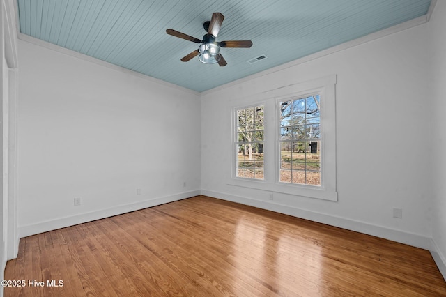 unfurnished room featuring visible vents, light wood-style floors, ornamental molding, a ceiling fan, and baseboards