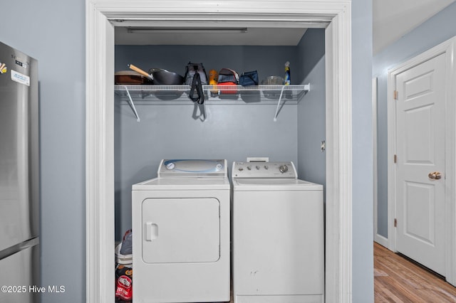 laundry room featuring laundry area, light wood-type flooring, and independent washer and dryer