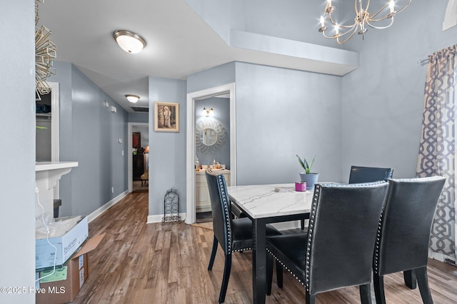 dining room with a notable chandelier, baseboards, and wood finished floors