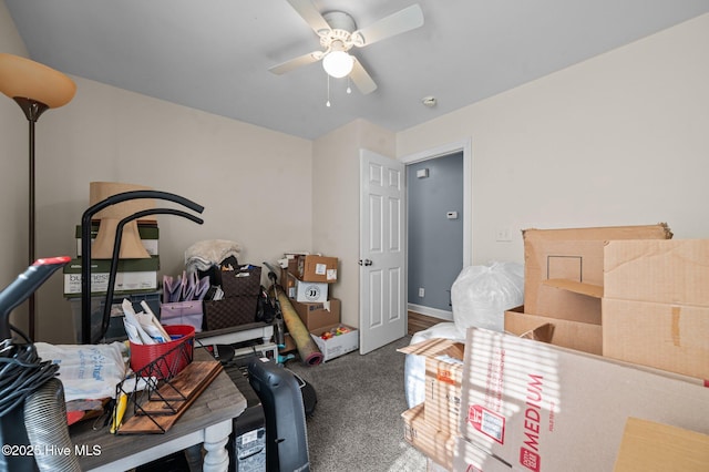 interior space with ceiling fan, dark colored carpet, and baseboards