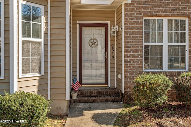 property entrance featuring brick siding