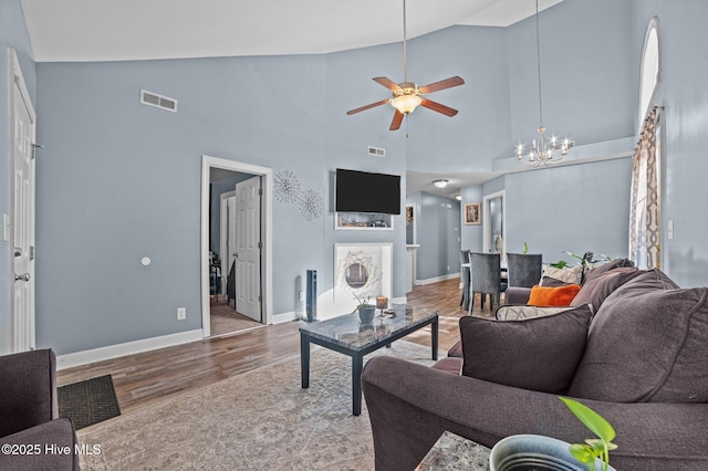 living room with baseboards, visible vents, wood finished floors, and ceiling fan with notable chandelier