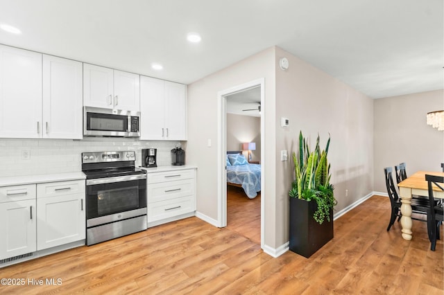 kitchen with stainless steel appliances, light countertops, light wood-style flooring, and tasteful backsplash