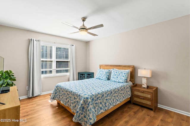 bedroom with wood finished floors, a ceiling fan, and baseboards