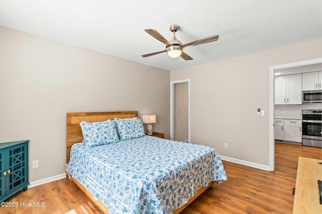 bedroom with ceiling fan, wood finished floors, and baseboards