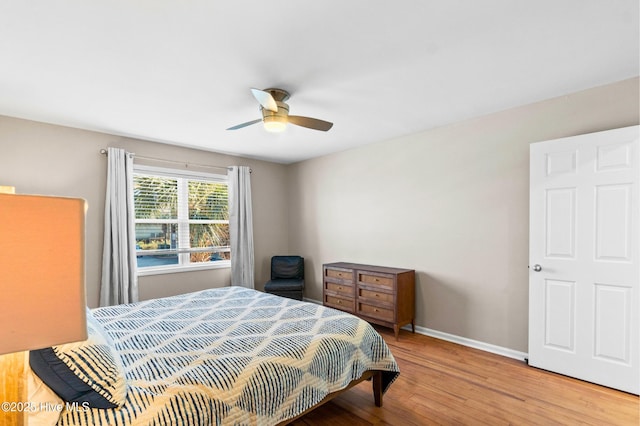 bedroom featuring ceiling fan, baseboards, and wood finished floors