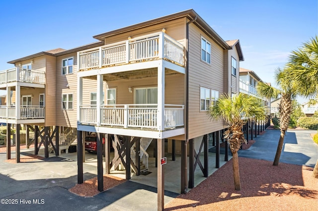 exterior space featuring a carport, stairs, and aphalt driveway