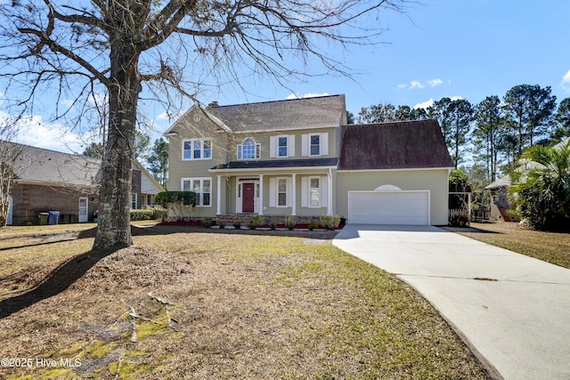 colonial home featuring driveway, a front lawn, and an attached garage