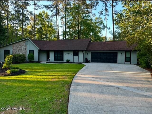 view of front of home with an attached garage, driveway, and a front yard