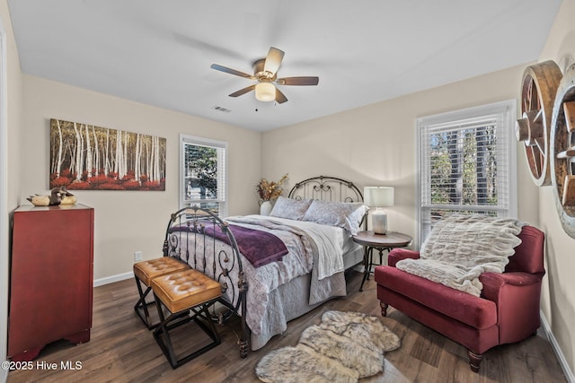 bedroom featuring multiple windows, visible vents, and dark wood-style flooring