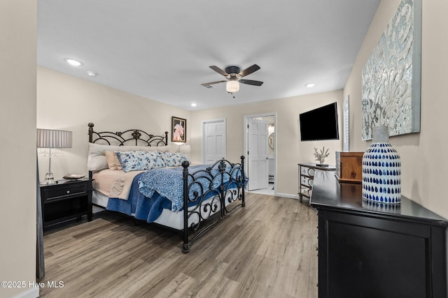 bedroom featuring ceiling fan, recessed lighting, wood finished floors, baseboards, and ensuite bath