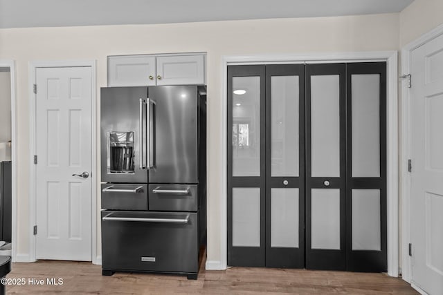 kitchen featuring white cabinets, light wood finished floors, and high end refrigerator