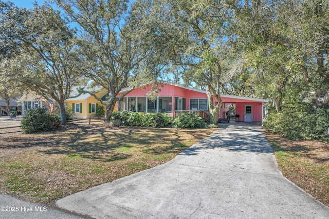 view of front of home with an attached carport, driveway, and a front lawn