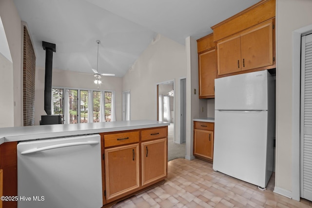 kitchen with light countertops, a ceiling fan, freestanding refrigerator, a wood stove, and dishwashing machine