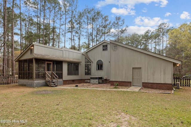 rear view of house featuring crawl space, a sunroom, fence, and a yard