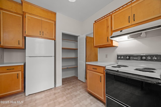 kitchen with light countertops, electric range, under cabinet range hood, and freestanding refrigerator