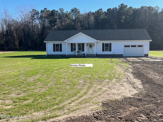 ranch-style home with a garage, dirt driveway, a forest view, covered porch, and a front yard