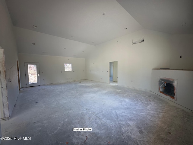 unfurnished living room featuring high vaulted ceiling and heating unit