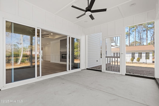 unfurnished sunroom with ceiling fan