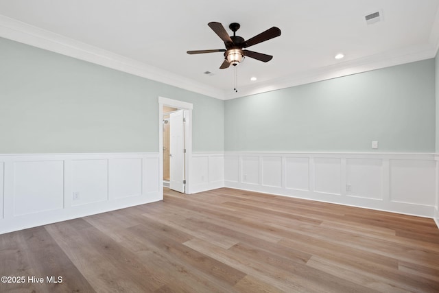 empty room featuring light hardwood / wood-style floors, ceiling fan, and crown molding