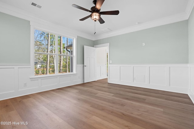 empty room featuring crown molding, ceiling fan, and wood-type flooring