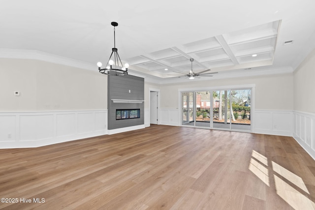 unfurnished living room with ceiling fan with notable chandelier, light hardwood / wood-style floors, coffered ceiling, a fireplace, and beamed ceiling