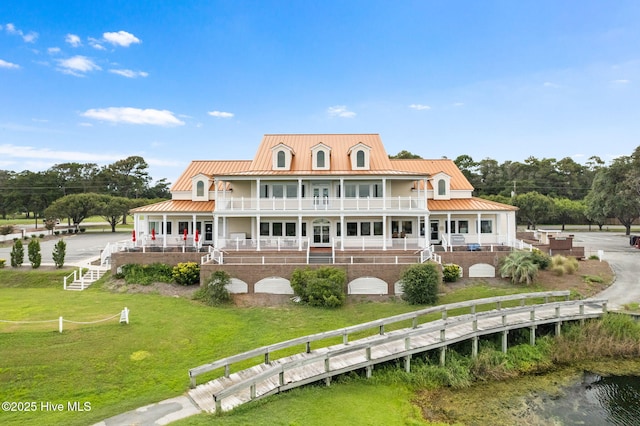 rear view of property featuring a lawn and a porch