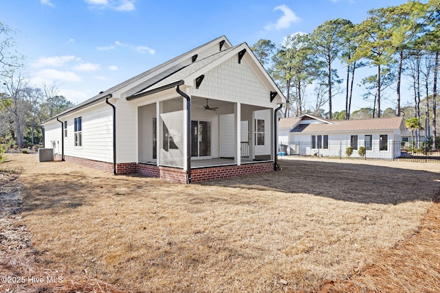 view of front of home with ceiling fan, a front lawn, cooling unit, and a sunroom