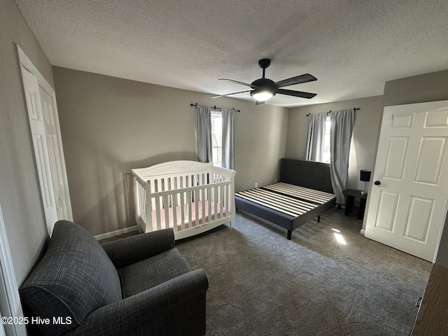 carpeted bedroom featuring a textured ceiling and a ceiling fan