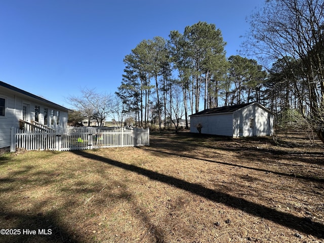 view of yard with an outdoor structure and fence