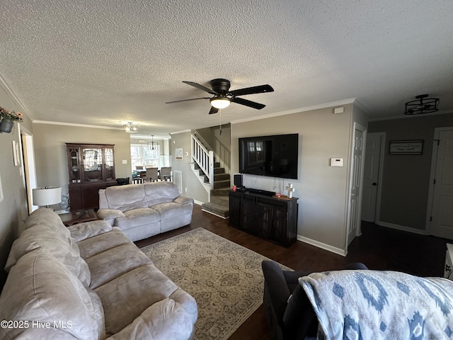 living area with ornamental molding, ceiling fan, wood finished floors, baseboards, and stairs