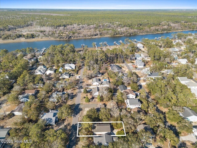 drone / aerial view with a water view, a wooded view, and a residential view