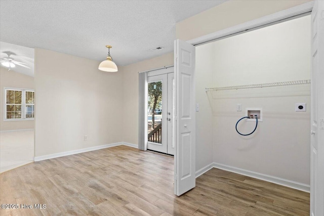 interior space featuring visible vents, a textured ceiling, baseboards, and wood finished floors