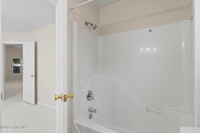 bathroom with shower / bathing tub combination, a textured ceiling, and baseboards