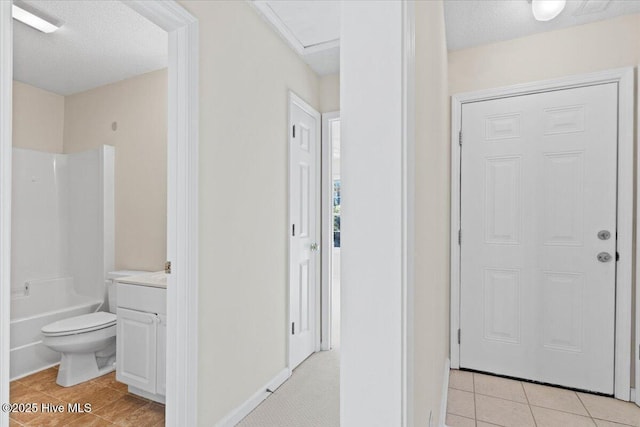 interior space featuring toilet, tile patterned floors, tub / shower combination, a textured ceiling, and vanity