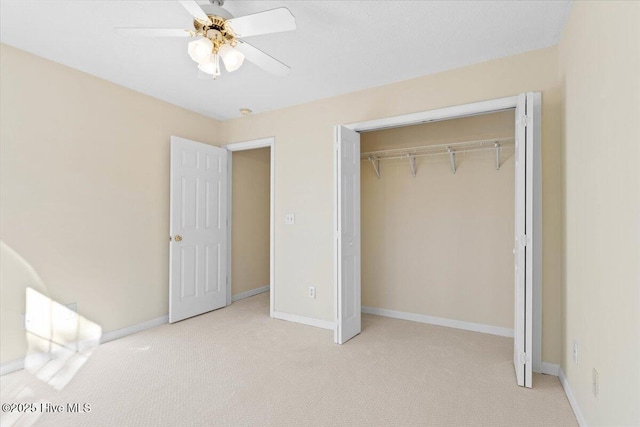 unfurnished bedroom featuring light carpet, baseboards, and a closet